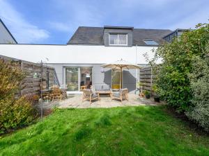 a patio with a table and an umbrella at Apartment Le nid du Golfe by Interhome in Mériadec