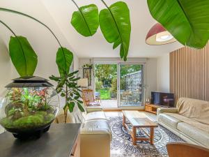 a living room with a couch and some plants at Apartment Le nid du Golfe by Interhome in Mériadec