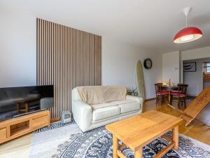 a living room with a white couch and a table at Apartment Le nid du Golfe by Interhome in Mériadec +16 photos