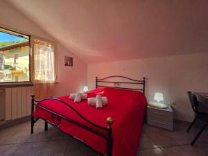 a bedroom with a red bed with a red blanket at La tua Vacanza al Mare in Borghetto Santo Spirito