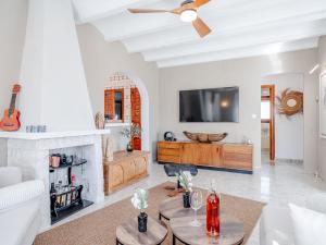 ein Wohnzimmer mit Kamin und Fernseher in der Unterkunft Holiday Home Olivia by Interhome in Fontilles