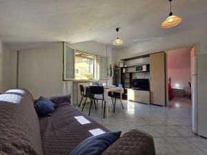 a living room and kitchen with a couch and a table at La tua Vacanza al Mare in Borghetto Santo Spirito