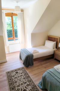 a bedroom with two beds and a large window at Holiday Home Heyward Mews - TR4 HH No 5 - Sleeps 5 by Interhome in Lispapple Cross Roads