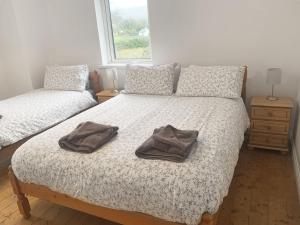 a bedroom with two beds with towels on the bed at Holiday Home Burren Seaside Lodge by Interhome in Ballyvaughan