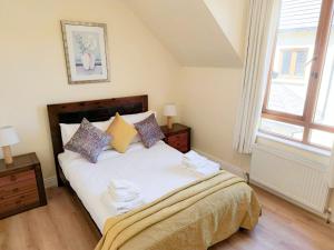 a bedroom with a bed with pillows and a window at Holiday Home Heyward Mews - TR4 HH No 5 - Sleeps 5 by Interhome in Lispapple Cross Roads