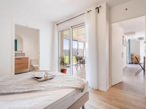 a white bedroom with a bed and a dining room at Holiday Home Bol d'Air by Interhome in Ploubalay