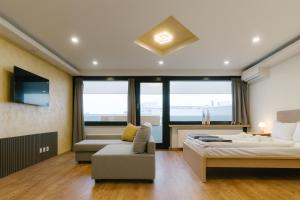 a bedroom with two beds and a couch and a tv at NEUES Apartment in Top Lage, free Parking max 1,65m Höhe und 1,8m Breite in Karlsruhe