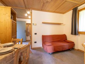 a living room with a chair and a table at Apartment Residence gli Scoiattoli-1 by Interhome in Madesimo