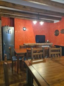 a dining room with wooden tables and a refrigerator at Tu Capricho in Piedralaves