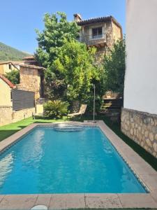 a large blue swimming pool in front of a building at Tu Capricho in Piedralaves