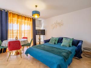 Un dormitorio con una cama azul y una mesa. en Studio Le Riviera-2 by Interhome, en Sainte-Maxime