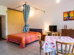 a bedroom with a bed and a table with a curtain at Studio B116 by Interhome in Cissano +15 photos