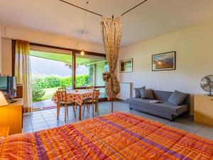 a bedroom with a bed and a table and a couch at Studio B116 by Interhome in Cissano