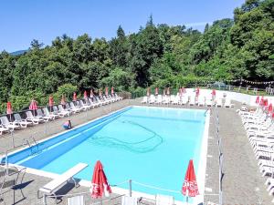 a large swimming pool with chairs and umbrellas at Studio B116 by Interhome in Cissano