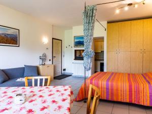 a bedroom with a bed and a couch and a table at Studio B116 by Interhome in Cissano