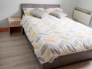 un grand lit dans une chambre avec une table de nuit dans l'établissement Holiday Home Seamount Holiday Village No 26 by Interhome, à Riverchapel