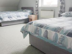 une chambre avec deux lits et une fenêtre dans l'établissement Holiday Home Seamount Holiday Village No 26 by Interhome, à Riverchapel