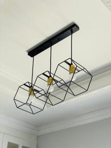 a chandelier hanging from a ceiling in a room at Beauty Blender Homes - The Monotone House in Lilongwe