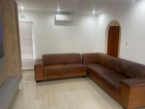 - un canapé en cuir brun dans le salon dans l'établissement 10 on Frangipani, à Richards Bay