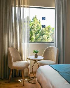 a room with two chairs and a table and a window at Palacio Pyramids Hotel in Cairo