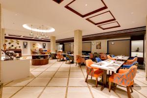 a dining room with tables and chairs in a restaurant at Lemon Tree Hotel, Motihari in Motīhāri