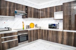 a kitchen with wooden cabinets and white appliances at Makupula Apartments in Lusaka