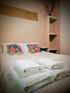 Un dormitorio con una cama con toallas. en Departamentos Tilcara, en Tilcara