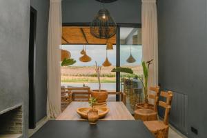 uma sala de jantar com mesa e cadeiras e uma janela em Palais Maya em Id Aïssa