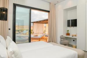 um quarto com uma grande cama branca e uma varanda em Palais Maya em Id Aïssa mais 46 fotografias