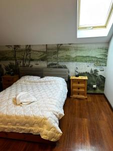 une chambre avec un lit et un tableau au mur dans l'établissement Pointview House Gesha, à Dryanovo