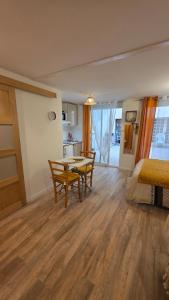 a room with a table and chairs and a bed at Studio cosy dans le cœur de Castelsarrasin in Castelsarrasin