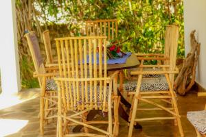 Una mesa y sillas de madera en un patio. en Mwazhouse, en Watamu 21 fotos más