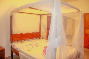 un dormitorio con una cama con dosel en Mwazhouse, en Watamu
