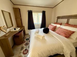 a bedroom with a large white bed and a mirror at The Waterfront in South Cerney