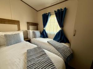 サウス・サーニーにあるThe Watersideの青いカーテン付きの部屋のベッド3台 +21枚の写真