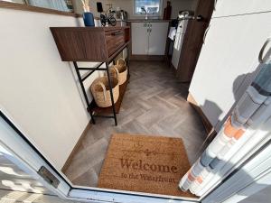 a view of a kitchen with a welcome to the victorian sign on the floor at The Waterfront in South Cerney