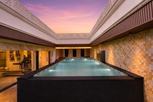 a swimming pool in a building with a ceiling at Lemon Tree Hotel, Motihari in Motīhāri