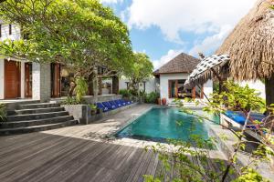 une cour arrière avec une piscine et une maison dans l'établissement Jabunami Villa, à Canggu