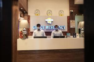 two men sitting at a counter with their laptops at Grace Residency Chennai Airport in Chennai