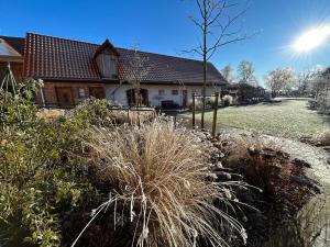 a house with tall grass in front of a yard at Landhaus Weserbergland in Vahlbruch