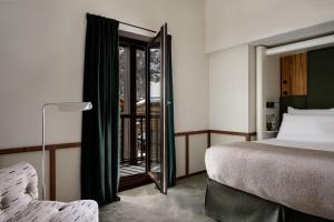 a bedroom with a bed and a mirror and a chair at Experimental Chalet Val d'Isère in Val dʼIsère +62 photos