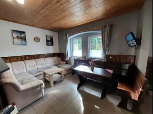 a living room with a piano and a couch at Apartmán Kameňák in Stožec