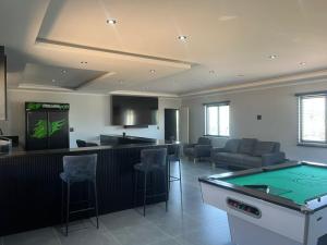 a room with a bar with a pool table at Pegasus Peak Lodge in Drummond
