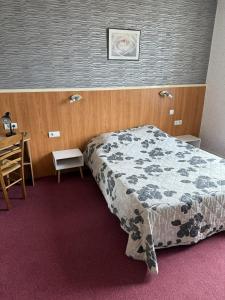 Un dormitorio con una cama y un escritorio. en Hôtel La Renaissance, en Arlanc
