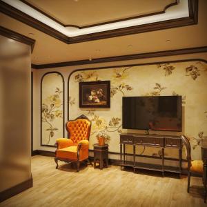 een woonkamer met een flatscreen-tv en stoelen bij Diamond Hotel in Long Biên