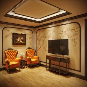 een kamer met 2 stoelen en een flatscreen-tv bij Diamond Hotel in Long Biên