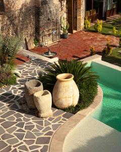 a garden with three vases sitting next to a pool at Kassandra Heritage in Fethiye +111 photos