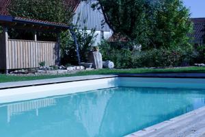 a swimming pool with blue water in a yard at Landhaus Weserbergland in Vahlbruch +41 photos