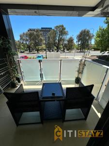 une vue d'un balcon avec une table et des chaises dans l'établissement Tranquil, Relaxing Forrest Style Apartment - Braddon CBD, à Canberra