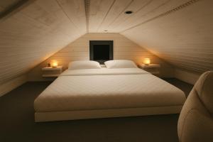 a large bed in a room with two lights at SMI'S Tiny in Ebensee